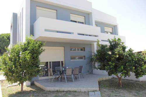 a building with a table and chairs in front of it at Platoni Elite in Ialyssos