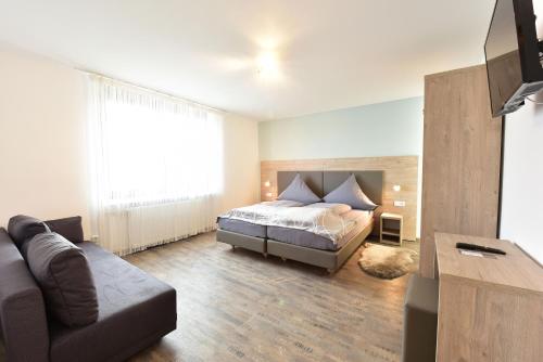 ein Schlafzimmer mit einem Bett und einem Sofa in der Unterkunft 1a Gästehaus am Hafen in Nürnberg