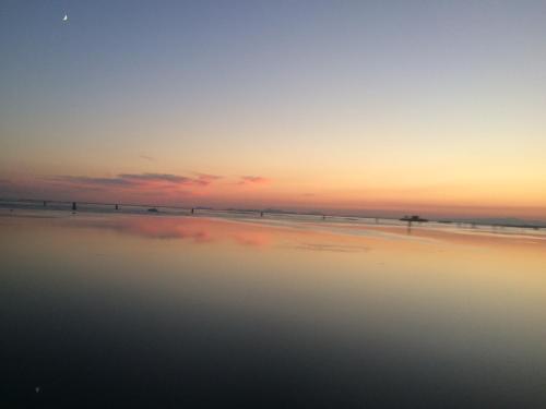 a sunset on a beach with the ocean at Appartamento Alla Riviera in Venice-Lido