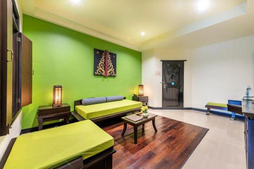 a living room with green walls and a couch at Chada Lanta Beach Resort - SHA Extra Plus in Ko Lanta
