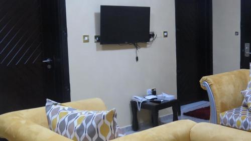 a living room with a couch and a flat screen tv at Address hotel Apartments العنوان للشقق الفندقية in Aş Şa‘arah