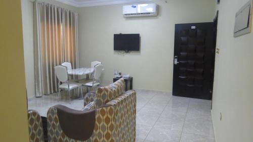 a waiting room with couches and a table and a television at Address hotel Apartments العنوان للشقق الفندقية in Aş Şa‘arah