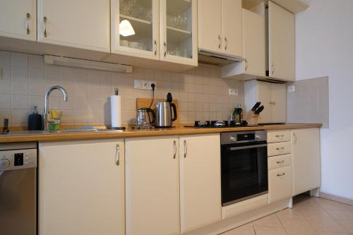 a kitchen with white cabinets and a stove top oven at Pawlansky Apartments No.4 in Prague