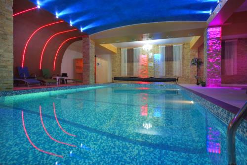 a large swimming pool in a hotel with a blue ceiling at Portile Ocnei in Târgu Ocna