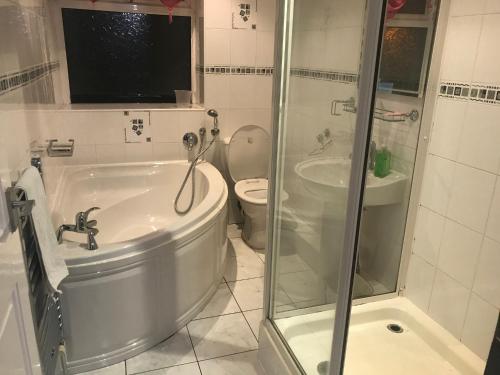 uma casa de banho com uma banheira, um WC e um chuveiro em Entire B&B em Burnley
