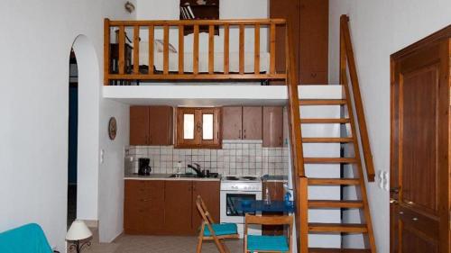 a kitchen with a staircase leading up to a loft bed at Stella's Home in Koufonisia