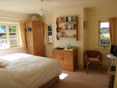 a bedroom with a bed and a desk and a tv at Gorse Farm House B&B in Sturminster Newton