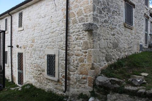 un antiguo edificio de piedra con ventanas laterales en Casavacanze Macchiametola en Lettomanoppello