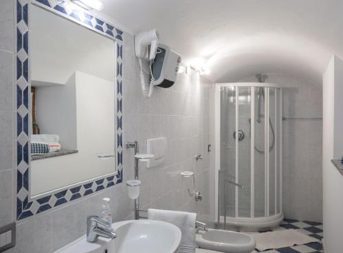 a bathroom with a sink and a shower with a mirror at Casa Domaso in Domaso