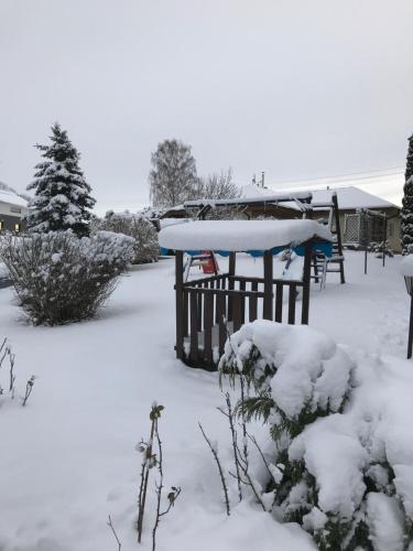 a yard covered in snow with a table and benches at Ferienhaus Zittau Oberlausitz & Ferienwohnung am Hamann Berg in Zittau