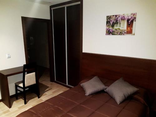 a bedroom with a bed and a picture on the wall at Complejo O Piñeiral A Fonsagrada in Fonsagrada