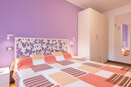 a bedroom with a large bed with a purple wall at Casa Domaso in Domaso