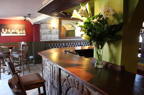 a vase of flowers on a bar in a restaurant at The Bell Inn in Worcester