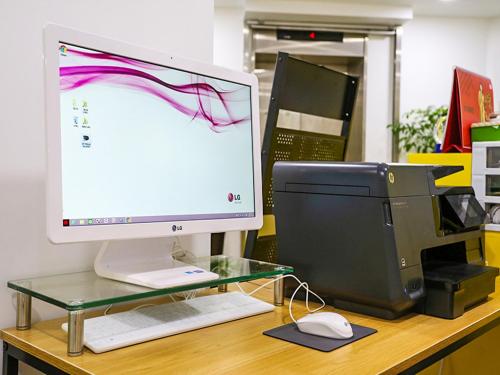 un monitor de ordenador y una impresora en un escritorio en 24 Guesthouse Seoul City Hall, en Seúl