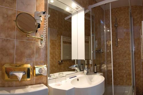 a bathroom with a sink and a shower with a mirror at Hotel Alter Speicher in Lübeck