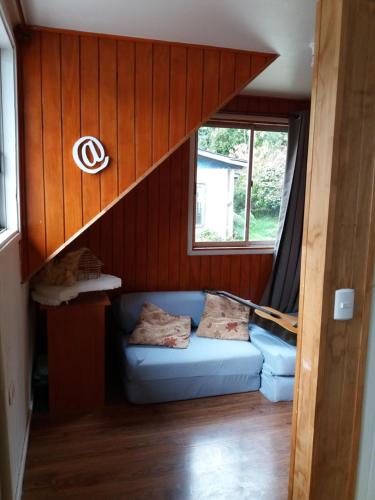 a living room with a blue couch in a house at Eco Nautic Hostel in Valdivia