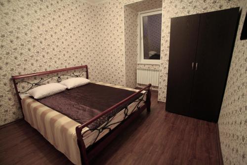 ペンザにあるGuest House Knots Landingのベッドルーム1室(ベッド1台、キャビネット、窓付)