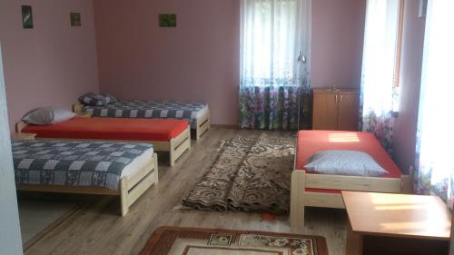 Habitación con 3 camas y mesa. en Chata Rybaka, en Suchowola