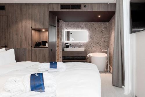 a bedroom with a large bed and a bathroom at Radisson Blu Hotel, Bruges in Bruges