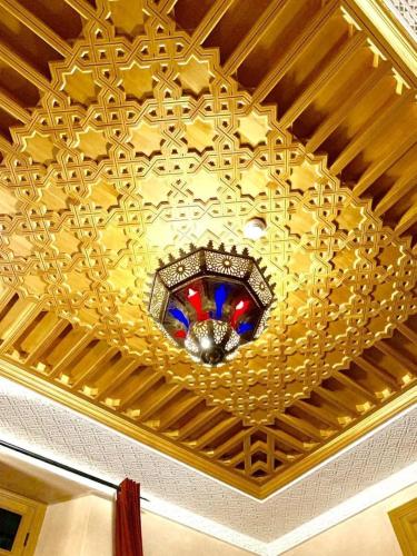 a ceiling with a chandelier and a stained glass window at Dar Al Madina Al Kadima in Fès