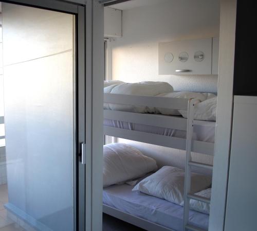 a room with four bunk beds in it with a mirror at Appartement Vue Mer 212 in Canet-en-Roussillon