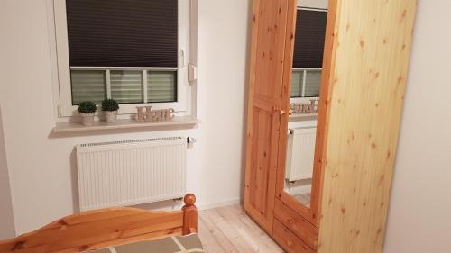 a room with a wooden door and two windows at Café Hausnordlicht - Ferienwohnung 2 in Dornum