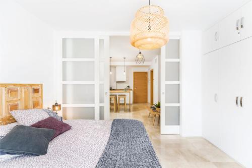 a bedroom with a bed and a dining room at Apartamento Lujo Ancha del Carmen in Málaga