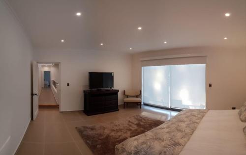 a bedroom with a bed and a flat screen tv at Pinares de Higuerillas in Maitencillo