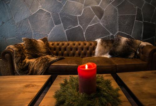 a living room with a couch with a red candle at Mountain Lodge in Stöten