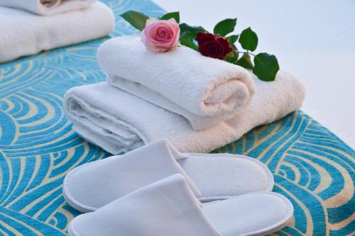a pile of towels with a rose on top at Hotel Loutraki in Loutraki