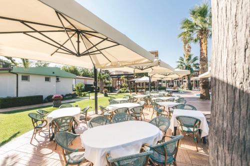 an outdoor patio with tables and chairs and umbrellas at Hotel Acquario in Vasto