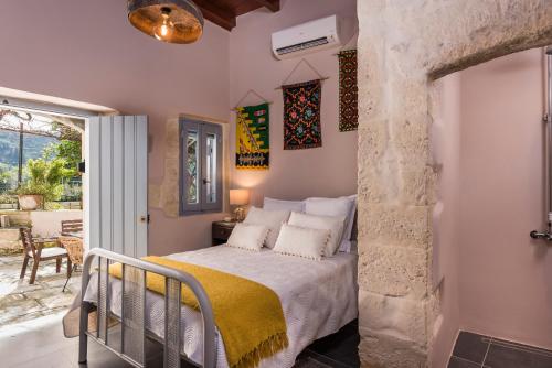a bedroom with a bed with a yellow blanket at Boutique Villa Kalliope in Gavalochori