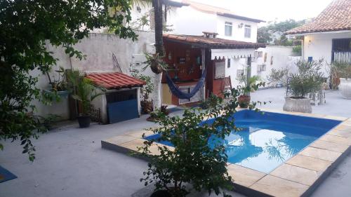 a swimming pool in a yard next to a house at Pousada Salvatore in Arraial do Cabo