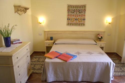a bedroom with a bed with two towels on it at Borgo Degli Ulivi in Àrbatax