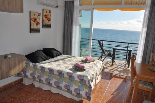a bedroom with a bed and a balcony with the ocean at Studio Vue Mer in Torremolinos