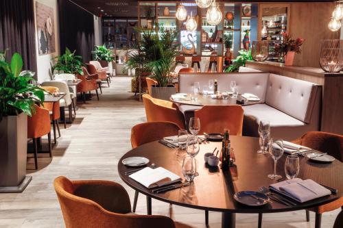 a dining room with tables and chairs and a bar at Radisson Blu Hotel, Bruges in Bruges