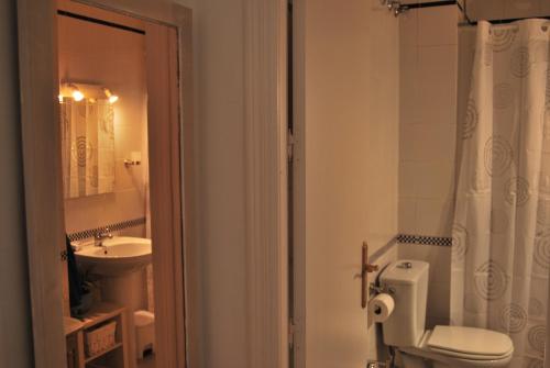 a bathroom with a white toilet and a sink at El Rincón de Aurora in Seville