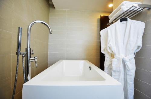 La salle de bains est pourvue d'un lavabo blanc et d'une douche. dans l'établissement San Cristobal Boutique Hotel - Ivato Airport, à Antananarivo