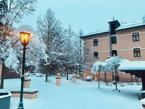 a street light covered in snow next to a building at Hotel BB Bahnhof Bertsdorf in Olbersdorf