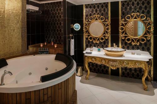 y baño con bañera, lavabo y espejo. en NG Afyon Wellness & Convention, en Afyon