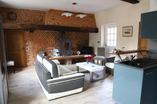 - un salon doté de meubles et d'un mur en briques dans l'établissement Maison de l'horloge, à Courcelles-sous-Moyencourt