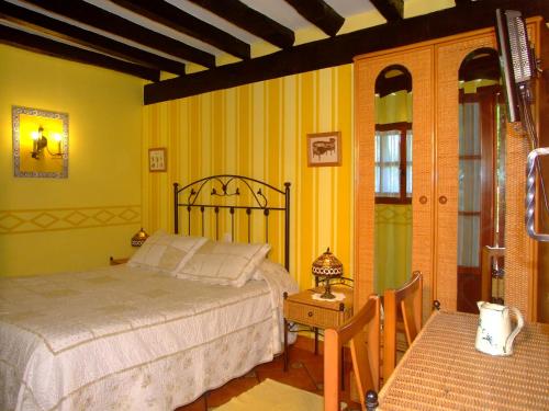 a bedroom with a bed and a table and chairs at Posada Gema in Ubiarco