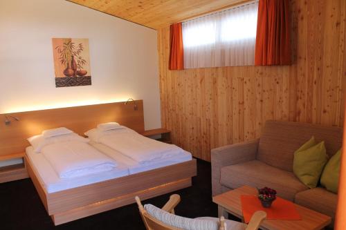 a hotel room with a bed and a couch at Gasthof zum goldenen Löwen in Nauders