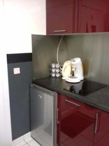une cuisine avec des armoires rouges et un mixeur sur un comptoir dans l'établissement chez christian&astrid Next to Disneyland Paris, à Penchard