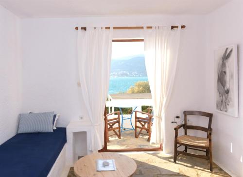 a room with a bed and a table and a window at Elounda Island Villas in Elounda