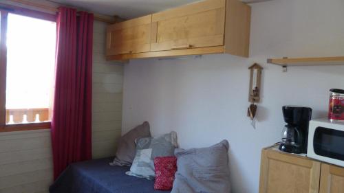 Cette petite chambre comprend un lit et un four micro-ondes. dans l'établissement LOCATION STUDIO 4 PERSONNES VALFREJUS - Les Melezets 1, à Valfréjus
