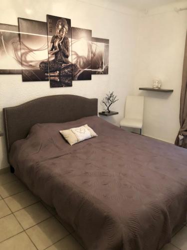 ein Schlafzimmer mit einem Bett mit vier Gemälden an der Wand in der Unterkunft villa Siana in Antibes