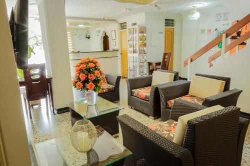 a living room with chairs and a table with a vase of flowers at Hotel Iguazu in Villavicencio