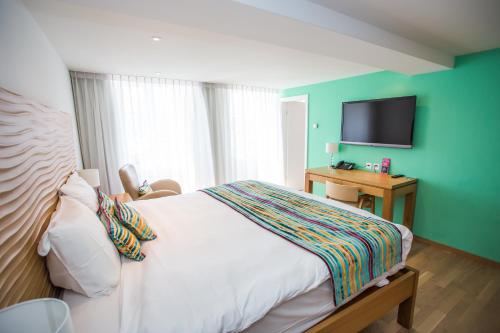 - une chambre avec un lit et une télévision à écran plat dans l'établissement Guest House Le Charlot, à Vevey