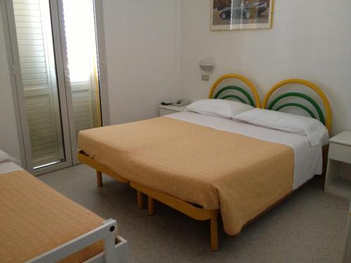 a bedroom with two beds and a rainbow headboard at Hotel Vienna in Senigallia
